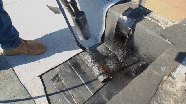 Roofer applying granulated APP Torch Down 