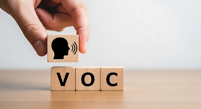 Hand placing wooden block with head silhouette and sound waves on V O C cubes
