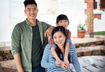 Obraz premium Asian family, kid and happy parents outdoor by home for connection, care and support with daughter. Portrait, girl and father with mother for bonding together, hug and embrace for love with smile