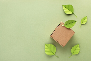 Single kraft box from recyclable organic materials with green leaf. Eco friendly packaging, zero waste and plastic free concept.