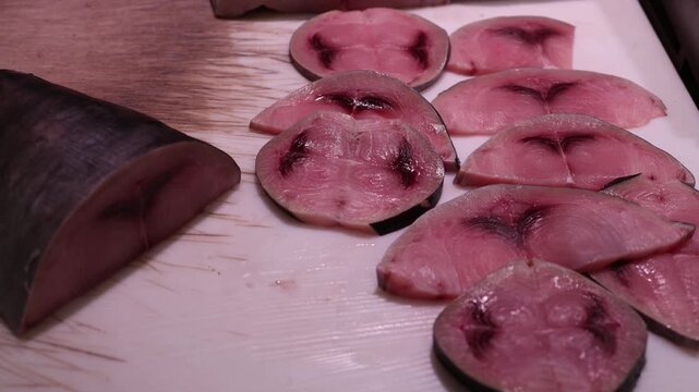 Fresh fish steaks sliced into round pieces on a clean cutting surface showing natural patterns pink tones smooth textures and a clear detailed seafood market preparation scenefish