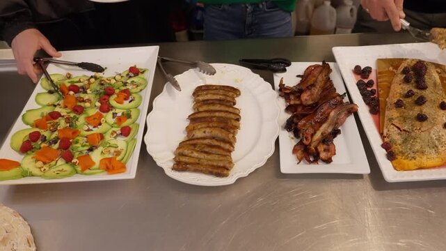 People lined up at a buffet taking food from a selection of salad, fish and sausages. Busy self-service dining scene in a restaurant or hotel, showing variety, hospitality and crowd movement