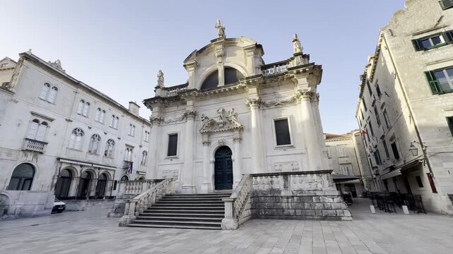 Cinematic b-roll of St Blaise Church facade in Dubrovnik Old Town at sunrise with empty square and no people - highlighting beautiful baroque limestone architecture and calm atmosphere
