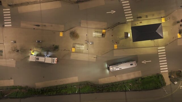 Vertical Aerial Top Down Track of Bus Driving in Carvolth Exchange Transit Terminal at Night