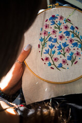 Close-up of a woman&rsquo;s hands stitching with embroidery thread. The image captures the creative process of hand embroidery, perfect for DIY crafts, needlework, and artistic hobbies.