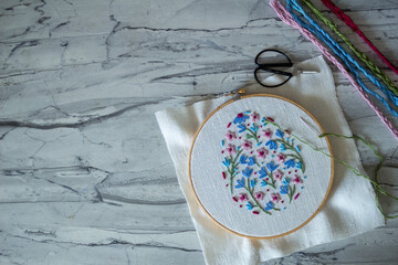 Hand-embroidered spring flowers in pastel pink, blue, and green tones. Close-up of floral design in an embroidery hoop, perfect for Easter, spring decor, and DIY hobby projects celebrating creativity 