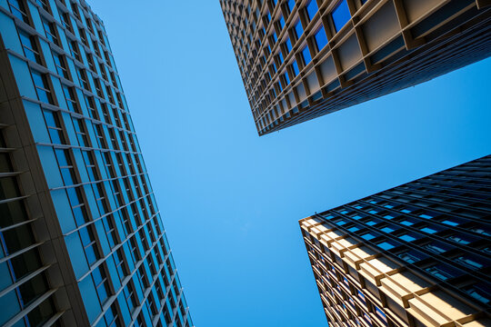 Modern urban architecture buildings shot upward in perspective with glass geometry and clear sky copyspace for magazine editorial layouts