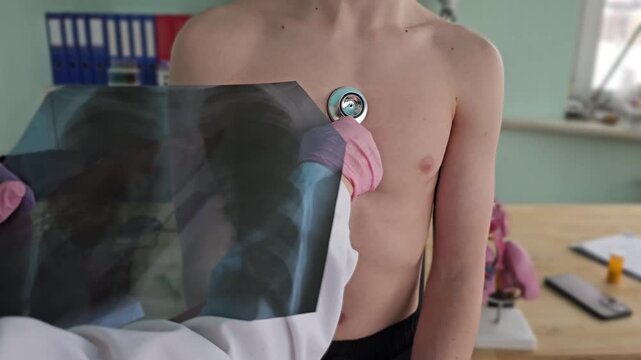 Child receives medical checkup in clinic with doctor using stethoscope on chest