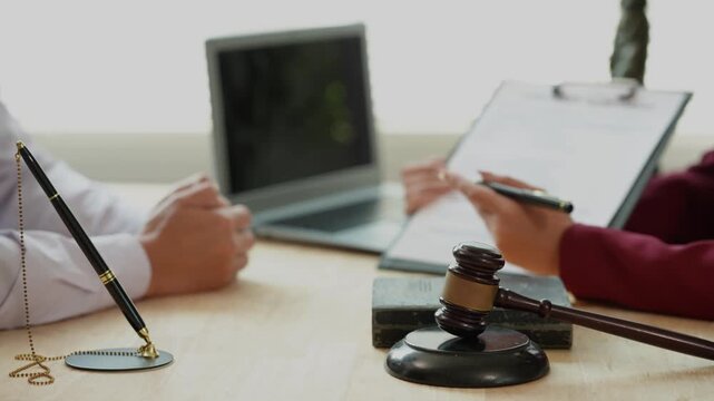 The concept of law and justice: The lawyer provides legal advice to young female lawyers, discusses legal documents, and offers guidance on important cases.