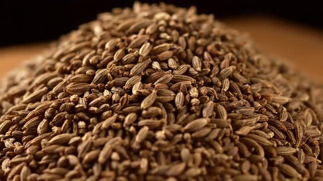 A detailed macro shot of a pile of cumin seeds, creating a warm and earthy mood. Perfect for food blogs, culinary websites, and recipe illustrations.