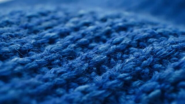 Close-up macro of vibrant blue knitted fabric texture, perfect for textile and craft design