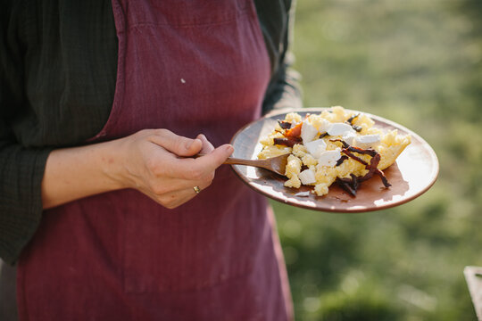 Woman holding traditional ukrainian kulesh with bryndza cheese