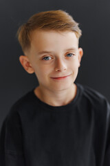 Girl holding a gift sits in front of a Christmas tree with lights