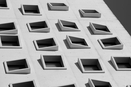 Modern architecture building facade with windows in minimal white geometry for urban pattern creating clean abstract repetition and depth