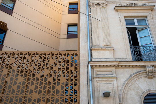 Modern architecture building facade beside heritage wall with contrast screen in urban scene showing detail texture and crafted patterns