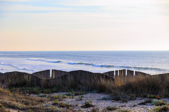 Wooden sand fence protecting dunes with ocean waves in background, Portugal, Ovar &ndash; Furadouro, 14 October 2025