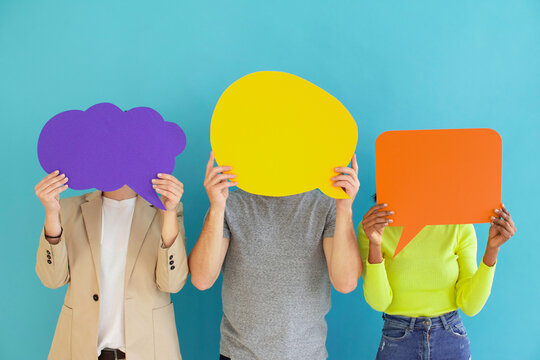Three people holding colorful blank speech bubbles