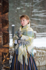 Latvian woman in traditional dress poses in a village in winter. Riga, Latvia.