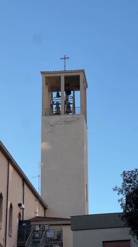 Vertical 4K video of simple church in Centocelle Rome with ringing bells on sunny day
