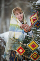 Latvian woman in traditional dress poses in a village in winter. Riga, Latvia.