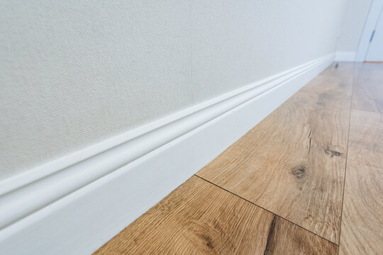 Refined Hallway With Natural Wood, Elegant White Walls With Oak Trim And Precise Molding, Finished Renovation Showcasing Subtle Shadow Lines And Clean Architectural Details