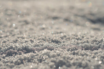 Close-up shows fresh, coarse-grained snow. Macro shot. Selective focus