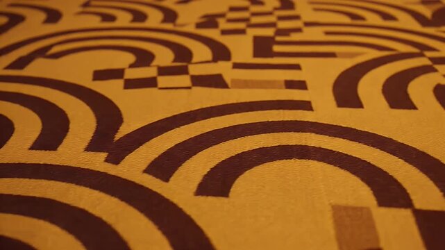 Close-up view of a textured surface with a repeating brown geometric pattern of arcs