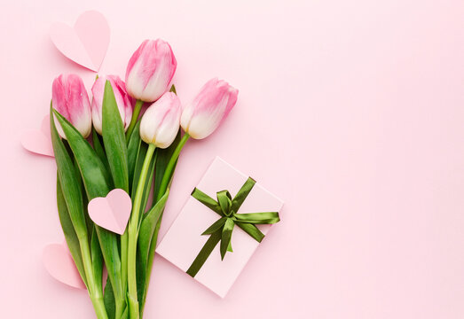 Elegant tulips with gift box on pink background
