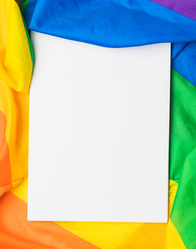 Colorful rainbow flag with a blank sheet of paper, representing diversity and lgbtq plus pride