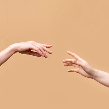 Artistic depiction of two beautiful women's hands reaching towards each other