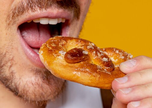 Man enjoying a delicious traditional german pretzel in closeup shot
