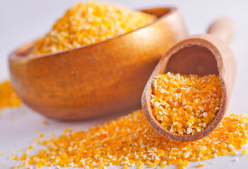 Raw cornmeal flour used in polenta, in wooden bowl