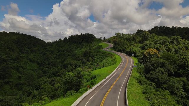 Serene aerial view of winding road through Thailands lush green mountain landscape peaceful journey exploring beautiful and scenic natural environment