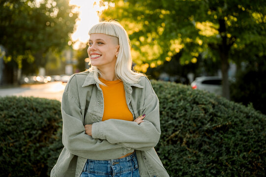 Smiling woman in casual clothes standing outdoors in a city
