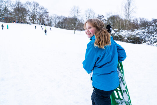Happy child enjoying sledding on snowy winter day outdoors