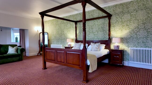 Opulent bedroom scene featuring a carved four-poster bed, side tables, lamps, and patterned wallpaper.