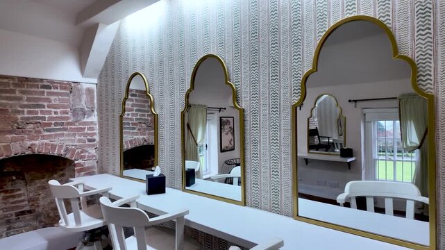 Interior of a vacant vanity suite featuring ornate mirrors and simple seating