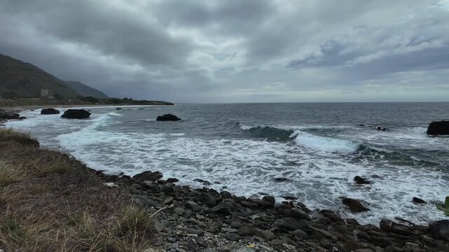 Dramatic wide shot capturing the raw intensity of the sea and fast-moving clouds over the rocky shoreline of La Guaira Venezuela
