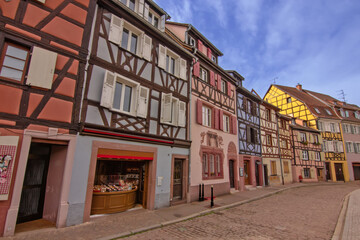 Historic colorful timber houses lining a quiet curved street in Colmar.