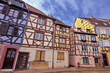 Historic colorful timber houses lining a quiet curved street in Colmar.