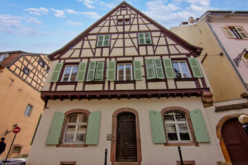 Colorful historic timber houses with flowers lining a narrow street in Colmar.