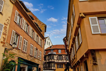 Colorful historic timber houses with flowers lining a narrow street in Colmar.