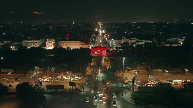 Aerial view of the city at night with brightly lit streets, buildings, and moving vehicles creating a vibrant urban landscape, Ashok Nagar, Rajasthan, India.