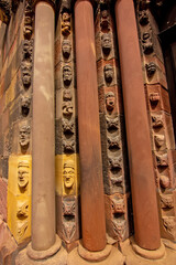 Naklejka premium Close view of carved Gothic church pillar showing medieval faces and stone ornament.