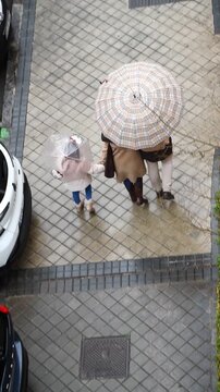 Familia con paraguas y chubasquero en d&iacute;a de lluvia
