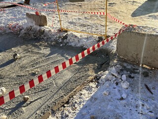 Roadwork construction site with barriers and tape in winter conditions  