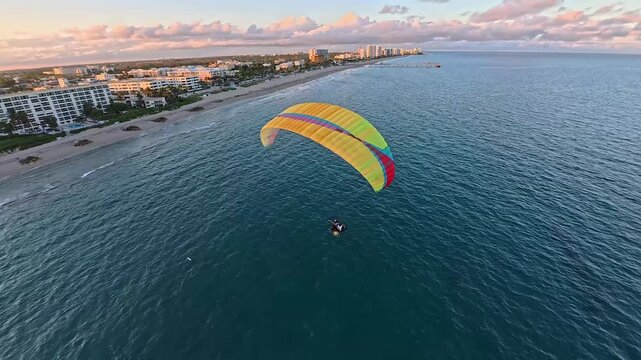 Aerial view of a paraglider soaring above the ocean contrasting against the coastal skyline, Deerfield Beach, Florida, United States.