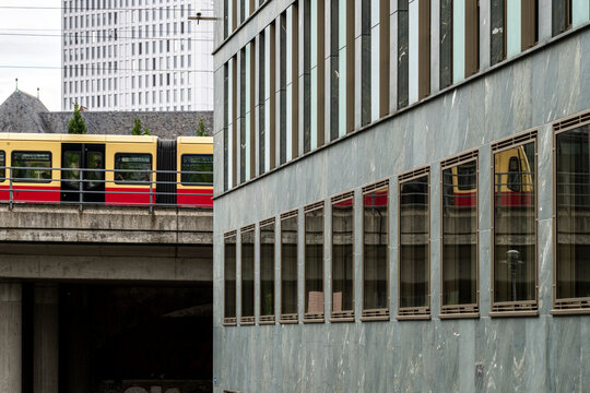 Modern office and urban railway viaduct with train in berlin germany showing transport infrastructure and commuter movement daily life