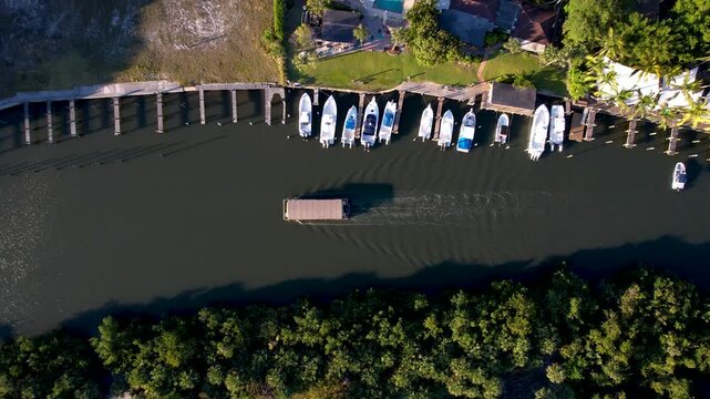 Aerial view of boats docked along a waterway, contrasting with the lush green vegetation and nearby houses, Jupiter, Florida, United States.