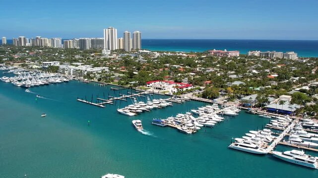 Aerial view of boats docked at the harbor with clear turquoise waters, contrasted by the city skyline, West Palm Beach, Florida, United States.